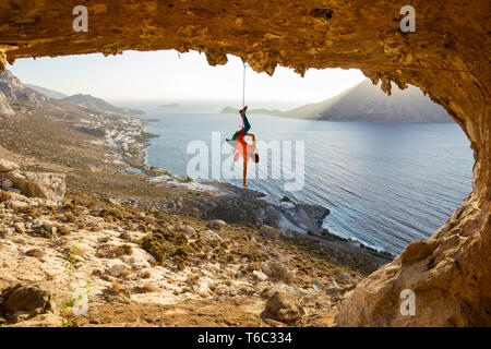 Rock climber hanging sur corde après être tombée de la falaise, l'escalade dans la grotte. L'île de Kalymnos, Grèce. Banque D'Images