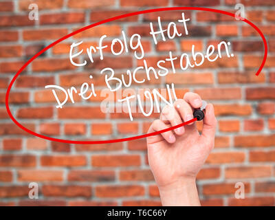 Man main écrit Erfolg Hat Drei Buchstaben : Tun ! (Le succès a trois lettres : n'en allemand) avec marqueur noir sur l'écran visuel Banque D'Images