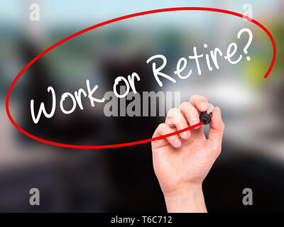 Man main écrit le travail ou la retraite ? Avec marqueur noir sur l'écran visuel Banque D'Images