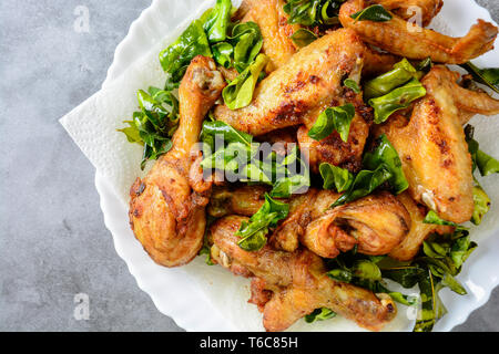 Ailes de poulet frit, la cuisse sur plaque blanche avec des herbes Banque D'Images