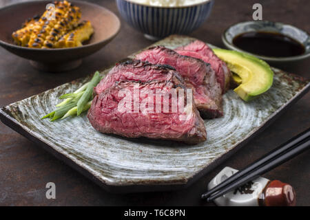 Filet de Bœuf de Kobe japonais avec du riz et de l'avocat comme close-up sur une plaque Banque D'Images