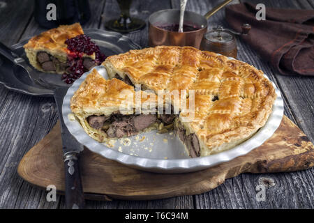 Tarte de venaison avec relish de canneberges en close-up dans un plat de support Banque D'Images