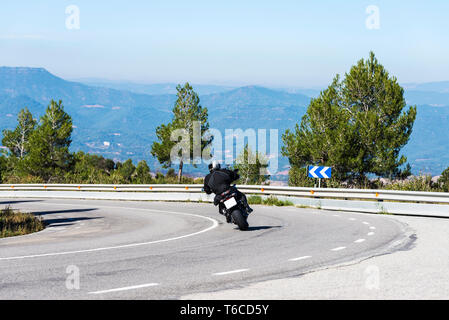 Moto entre dans une courbe sur une route de campagne en Espagne Banque D'Images