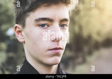 Close up portrait of a young man in a park Banque D'Images