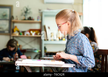 Très jolie jeune femme souriante profiter de leur temps à art studio. la photo en gros plan. Leçons de sculpture. petite fille fait une pportrait de nice. Banque D'Images