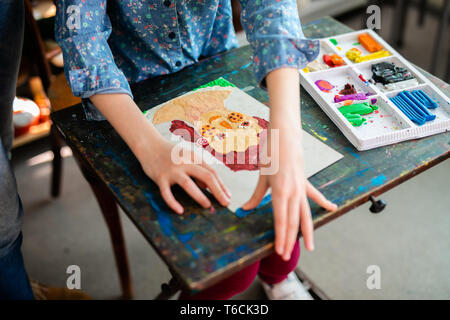 Très jolie jeune femme souriante profiter de leur temps à art studio. la photo en gros plan. Leçons de sculpture. petite fille fait une pportrait de nice. Banque D'Images