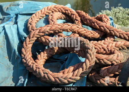 Corde orange enroulé sur une feuille bleue. Banque D'Images