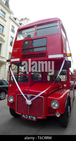 Un bus Routemaster rouge sur une rue de Londres avec ruban mariage. Banque D'Images