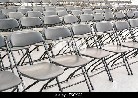 Des rangées de chaises pliantes noir vide dans une salle de conférence Banque D'Images