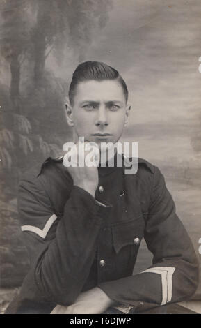 Vintage Portrait photographique Carte postale montrant un jeune homme séduisant élégant portant un uniforme militaire Banque D'Images