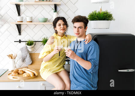 Jeune couple - un garçon et une fille, avoir du plaisir dans la cuisine, boire des cocktails. Banque D'Images