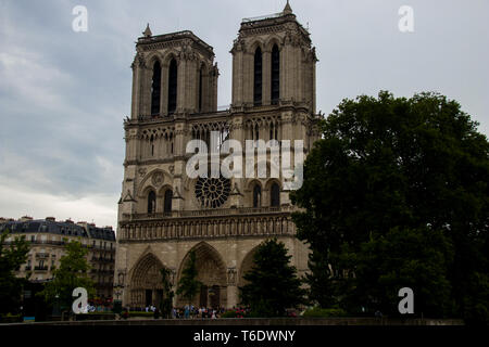 Les tours de Notre Dame. Mis en évidence par l'immense rosace et un ciel couvert d'ombre. Banque D'Images