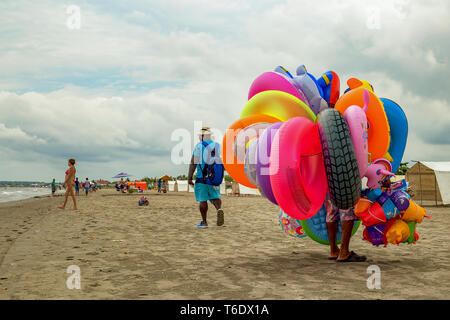 La Boquilla, Carthagène, Colombie - 18 septembre 2017 : Un vendeur de flottaison promenades sur une plage presque déserte en basse saison. Banque D'Images