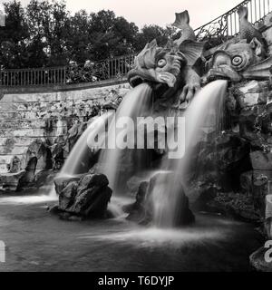 La fontaine du Dauphin avec l'eau qui coule dans le jardin du Palais Royal de Caserta, Italie. Image en noir et blanc. Banque D'Images