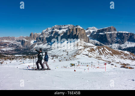 Deux skieurs à la recherche de l'autre côté de la vallée Val di Fassa Dolomites sur la pente de ski Banque D'Images