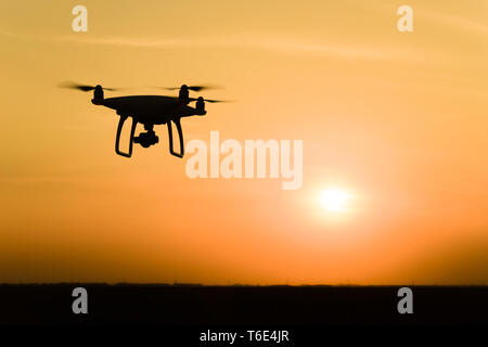 Silhouette Quadrocopters contre l'arrière-plan de la coucher du soleil Banque D'Images