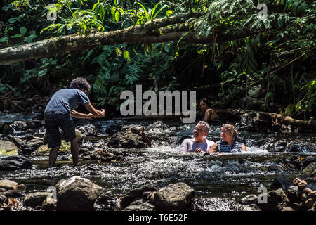 Une belle photo d'un garçon à prendre des photos d'un couple marié profiter du beau parc naturel ecotermales (hot springs) à Tabacon, La Fortuna, Costa Rica Banque D'Images