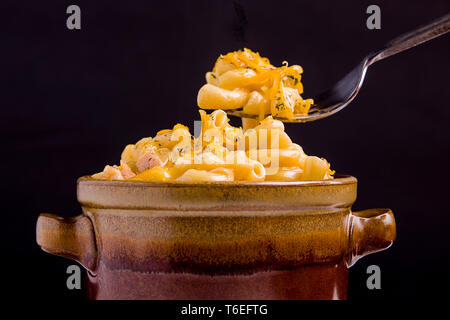 Un portrait photo de macaroni au fromage dans un bol et sur la fourche au-dessus. Banque D'Images