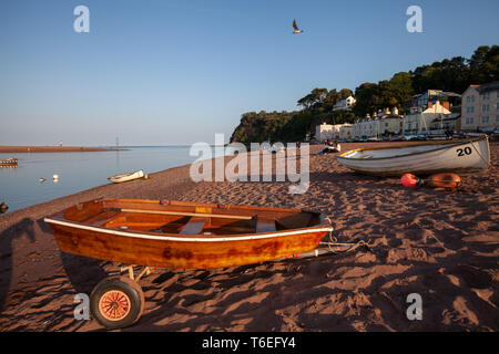 Une plage vide avec un bateau de ligne en bois assis sur une remorque sur une soirée ensoleillée Banque D'Images