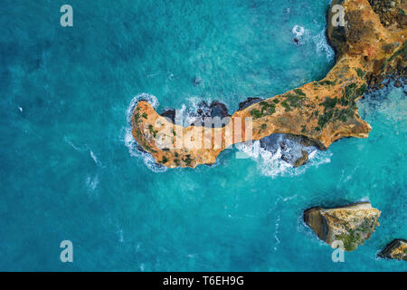 En regardant l'océan turquoise vagues se brisant sur les rochers - vue aérienne Banque D'Images