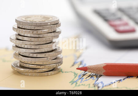 Les pièces en euros empilés et calculatrice portant sur les affaires financières de marché boursier Banque D'Images