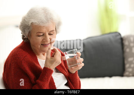 Femme âgée en tenant comp à la maison Banque D'Images