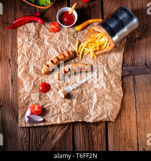 Bratwurst rustique avec pommes et ketchup fort Banque D'Images