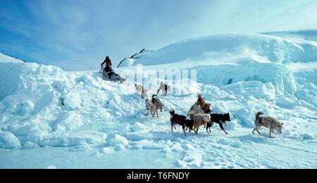 Les Inuit avec sledgies chien voyageant en amont, des luges ultra légère et flexible sont utilisés pour les voyages en montagne, à l'Est du Groenland, Greenland Banque D'Images