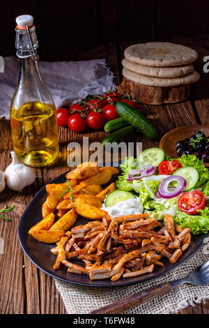 Il plaque gyros rustique salade verte et les quartiers de pommes de terre Banque D'Images