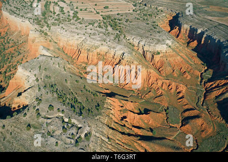 VUE AÉRIENNE. Mesa semi-aride avec ses falaises de strates multicolores. Cañon Rojo (aussi connu sous le nom de Rambla de Barrachina), Teruel, Aragon, Espagne. Banque D'Images