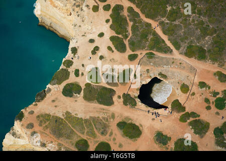 VUE AÉRIENNE. Algar de Benagil : une grande grotte de mer photogénique sur la côte accidentée de l'Algarve. Lagoa, Portugal. Banque D'Images