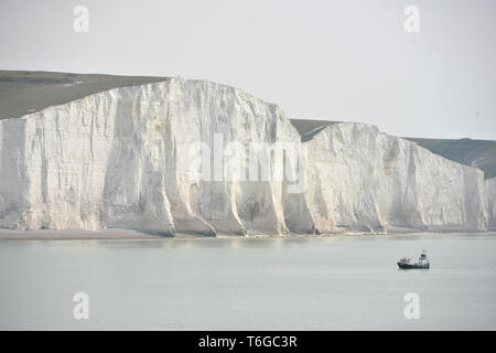 Cuckmere Haven, East Sussex, UK. 1er mai 2019. Un petit bateau de pêche à la base de travail de l'icône de sept Sœurs des falaises de craie sur l'image près de Eastbourne, facile Sussex, sur une journée brumeuse. Crédit : Peter Cripps/Alamy Live News Banque D'Images
