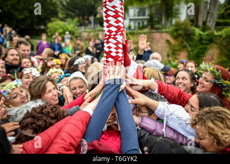 Mains toucher le poteau "maypole" pendant la célébration Beltane à Glastonbury Chalice Well, où les gens se rassemblent pour observer une interprétation moderne de l'antique fertilité païenne celtique sacre du printemps. Banque D'Images