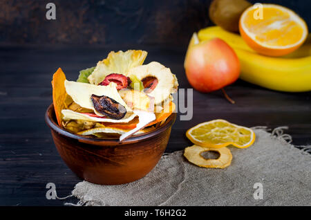 De nombreux fruits divers plaquettes fixées dans un bol en bois sombre sur fond , concept de vie saine et une bonne nutrition, snack, vue du dessus, copy space Banque D'Images