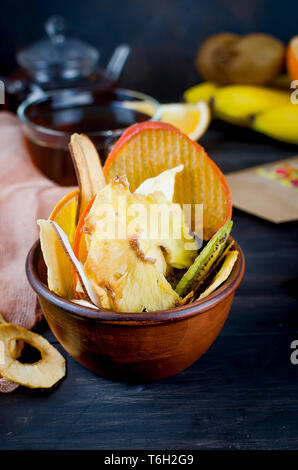 De nombreux fruits divers plaquettes fixées dans un bol en bois sombre sur fond , concept de vie saine et une bonne nutrition, snack, vue du dessus, copy space Banque D'Images