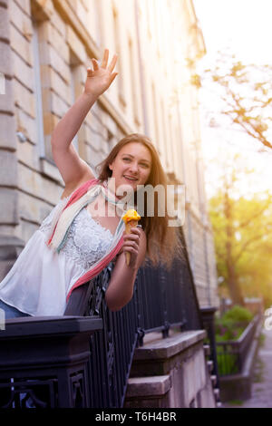 Jeune brunette woman outdoor holding ice cream et saluer quelqu'un Banque D'Images