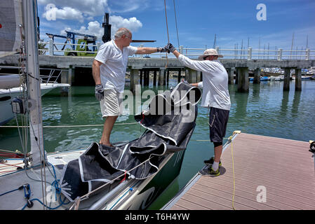 Yachting. Groupe d'amis préparant leur petit yacht pour un voyage en bateau. Banque D'Images