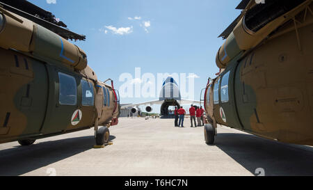 Les membres de l'équipe d'une industrie de défense à base de Huntsville entrepreneur, SES-i, qui ont rénové ces deux hélicoptères UH-60 Black Hawk pour l'Afghanistan sous un commandement de l'armée américaine d'assistance à la sécurité cas de vente militaire étrangère, préparez-vous à télécharger les hélicoptères dans un Antonov AN-124, à l'aérodrome de Huntsville, AL, 26 avril 2019. US Army photo de Richard Bumgardner USASAC, Affaires publiques. Banque D'Images