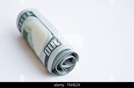 One hundred dollar bills roulé dans un tube sur un fond clair Banque D'Images