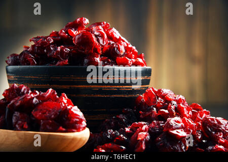 La composition avec bol de canneberges séchées sur table en bois. Banque D'Images