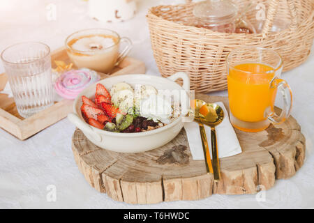 Mélangez le yaourt de fruits avec petit déjeuner avec jus d'orange dans l'éclairage du matin. Banque D'Images