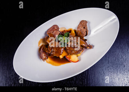 Foie gras de canard avec sauce aux baies et pommes décorées avec du romarin. Banque D'Images