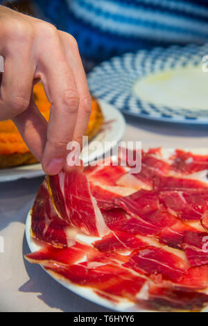 La main de l'homme avoir jambon ibérique. L'Espagne. Banque D'Images