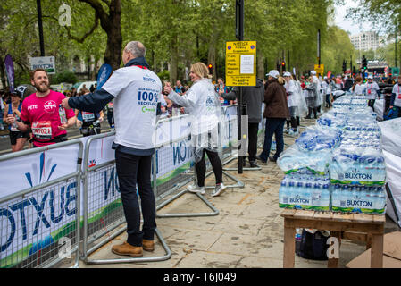 Poste d'eau au Marathon de Londres 2019 Buxton servant des bouteilles d'eau. Des bouteilles en plastique. Bouteille en plastique. Station de ravitaillement pour les coureurs. Packs Banque D'Images