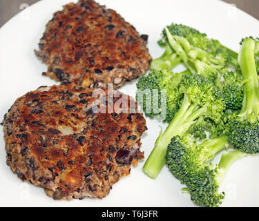 Des burgers de haricots noirs avec un côté du brocoli frais Banque D'Images