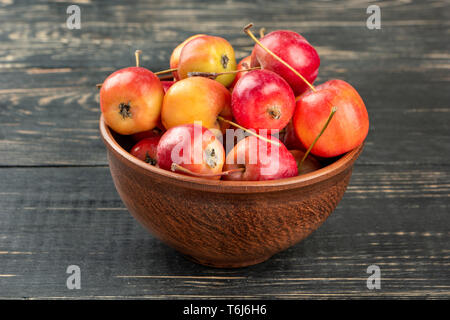 Paradis frais dans un bol de pommes sur fond de bois Banque D'Images