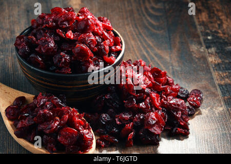 La composition avec bol de canneberges séchées sur table en bois. Banque D'Images