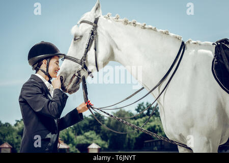 Belle belle femme debout devant son cheval Banque D'Images