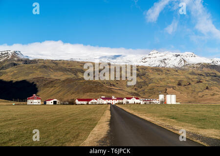 Vue d'une route menant à une ferme au pied du volcan Eyjafjallajökull couverte de neige. Le volcan errupted célèbre en 2010. Banque D'Images