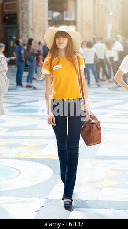 Modèle avec un chapeau de paille promenades dans la galerie Umberto primo à Naples. Banque D'Images